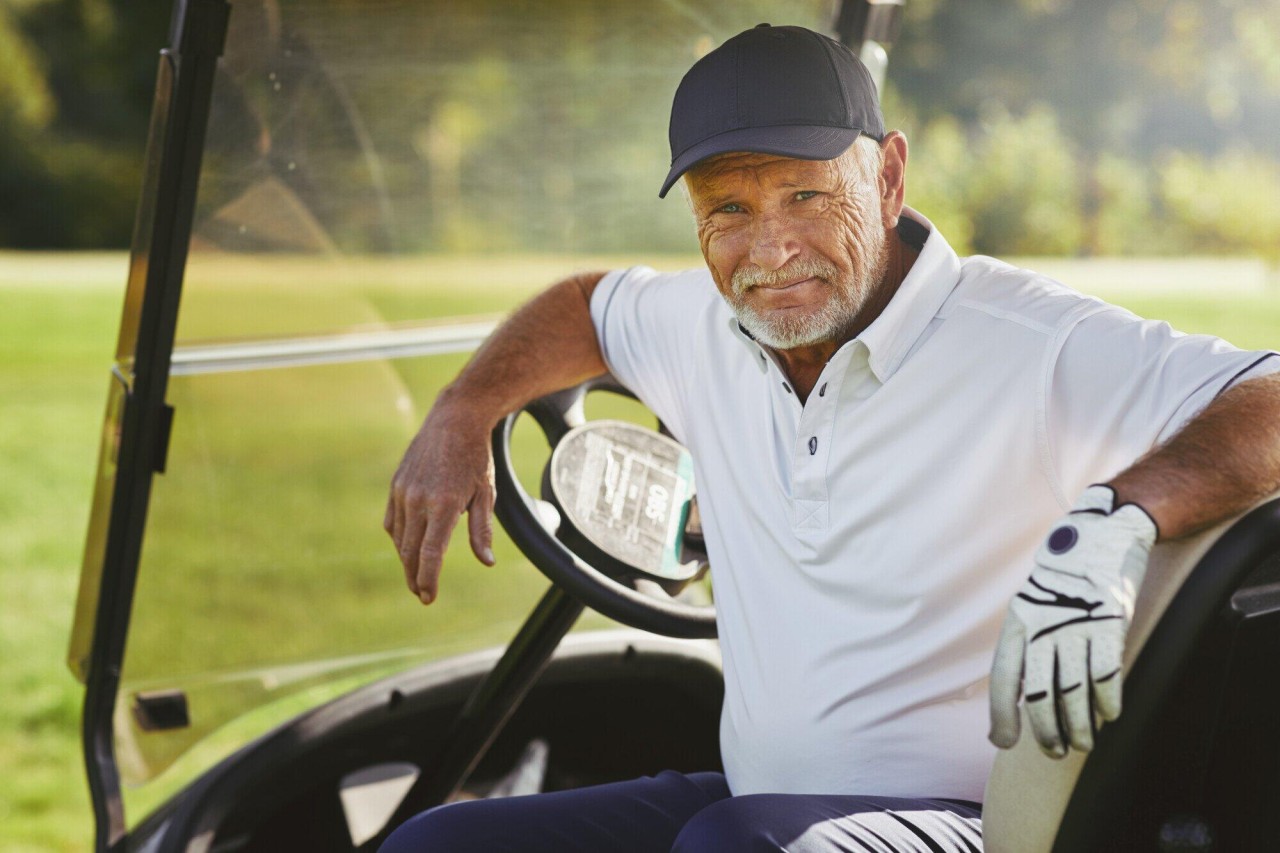 senior-man-smiling-while-sitting-in-golf-cart